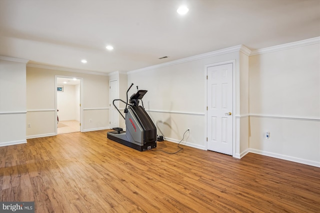 exercise room featuring wood finished floors, crown molding, recessed lighting, and baseboards