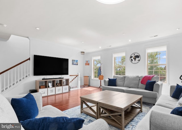 living room featuring wood finished floors, ornamental molding, and recessed lighting