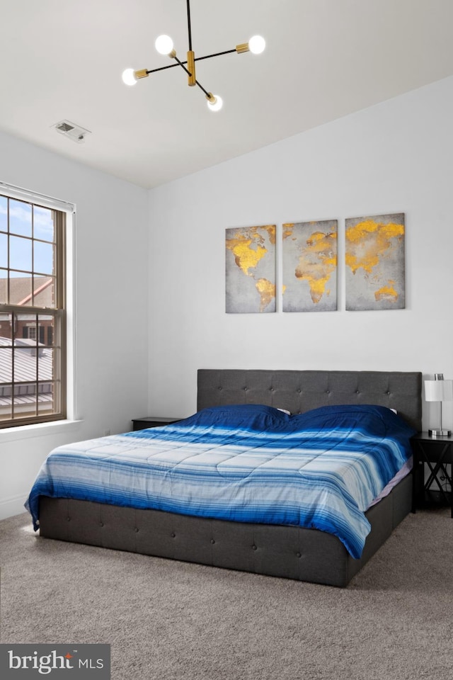 carpeted bedroom featuring a chandelier