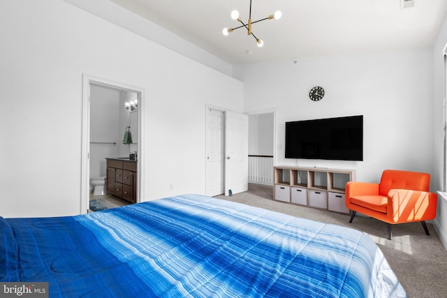 carpeted bedroom featuring a chandelier, baseboards, and ensuite bathroom
