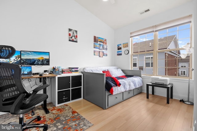 bedroom featuring lofted ceiling, light wood-type flooring, and baseboards