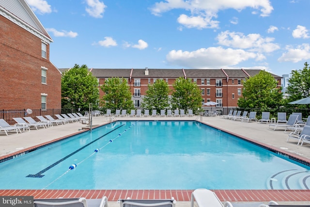 community pool with fence and a patio area