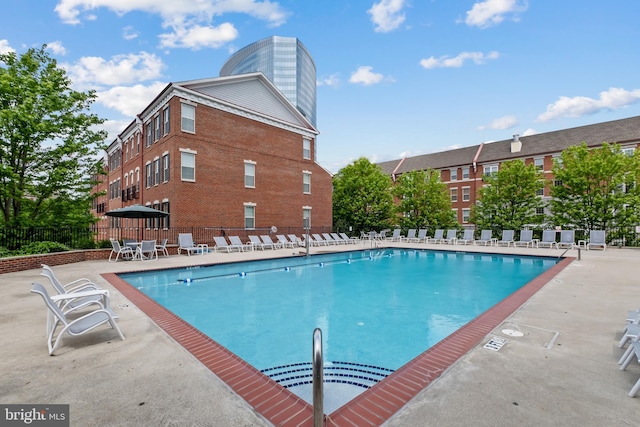community pool with fence and a patio area