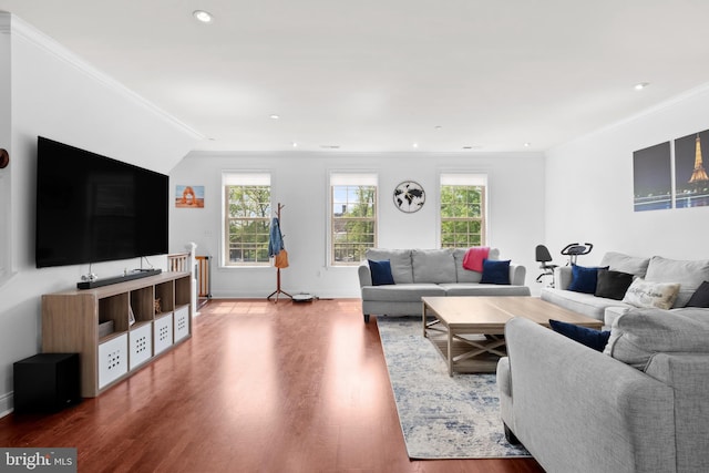 living room with wood finished floors, ornamental molding, baseboards, and recessed lighting