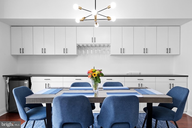 dining area with dark wood-type flooring, a chandelier, and baseboards
