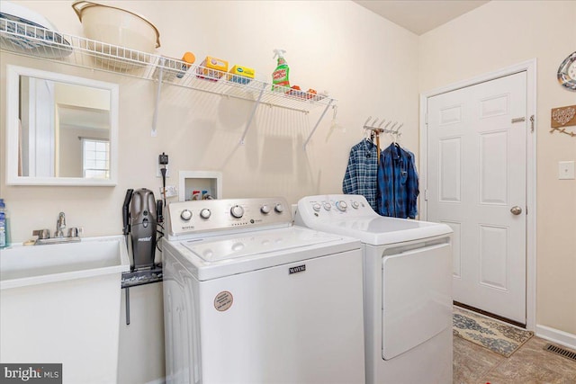 laundry room with laundry area, visible vents, washing machine and dryer, and a sink