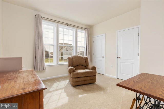 sitting room featuring baseboards, a wealth of natural light, and light carpet