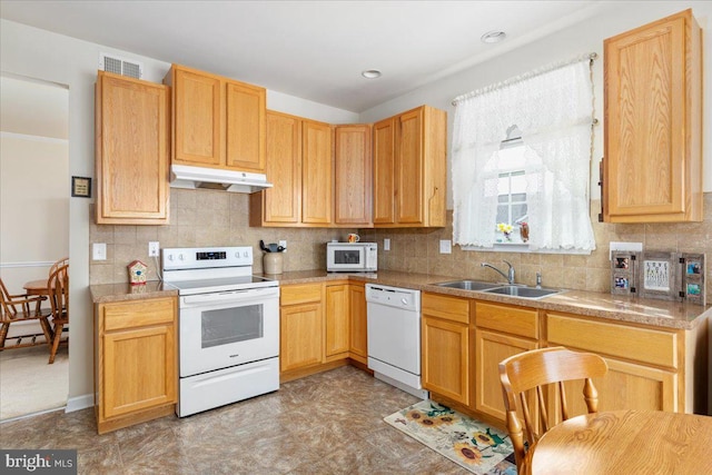 kitchen featuring a sink, visible vents, white appliances, under cabinet range hood, and decorative backsplash