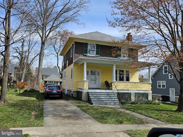 traditional style home featuring a chimney, a front lawn, covered porch, and concrete driveway