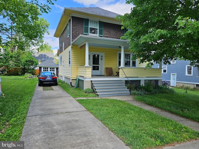american foursquare style home with covered porch, concrete driveway, and a front lawn
