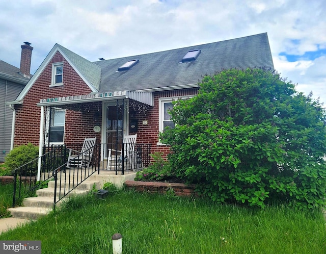 view of front facade featuring a shingled roof and brick siding