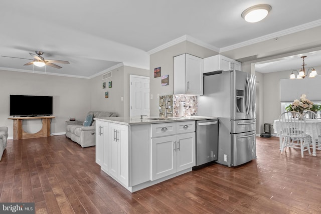 kitchen featuring appliances with stainless steel finishes, white cabinets, a sink, dark wood-type flooring, and ornamental molding
