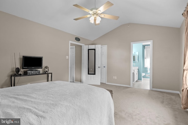 carpeted bedroom featuring lofted ceiling, baseboards, ensuite bath, and ceiling fan