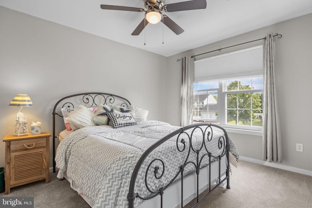 carpeted bedroom featuring baseboards and ceiling fan