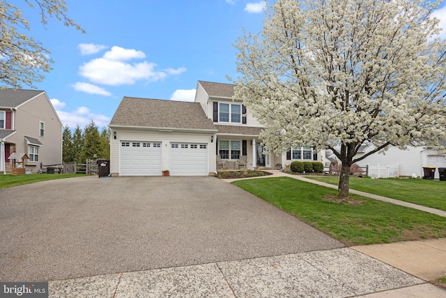 view of front of property featuring asphalt driveway, an attached garage, a front lawn, and roof with shingles