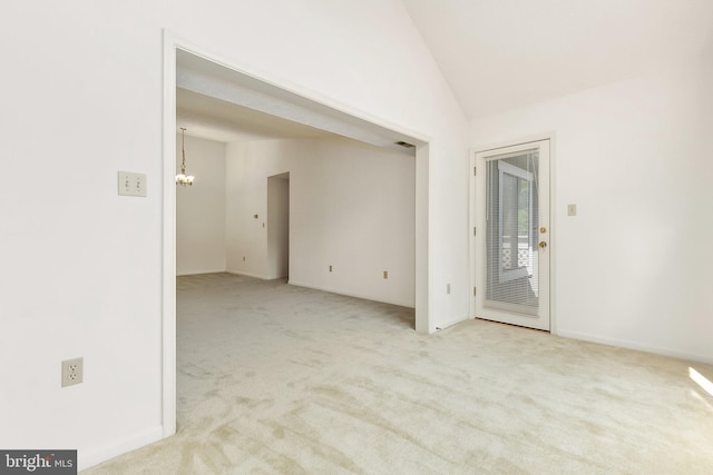 empty room with carpet flooring, lofted ceiling, and a chandelier