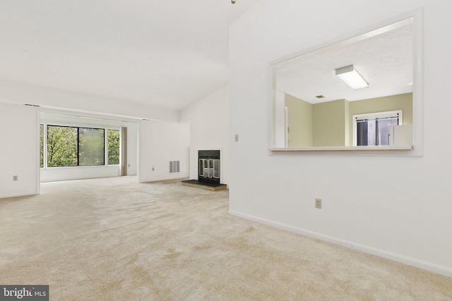 unfurnished living room with carpet flooring, a glass covered fireplace, high vaulted ceiling, and baseboards