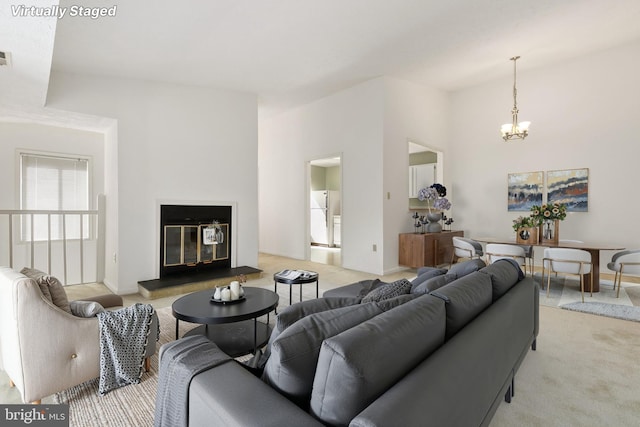 living area with light carpet, a chandelier, vaulted ceiling, and baseboards