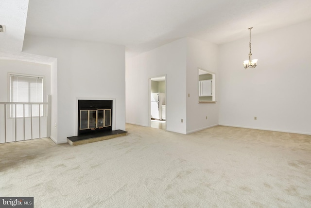 unfurnished living room with carpet floors, a chandelier, a glass covered fireplace, and baseboards