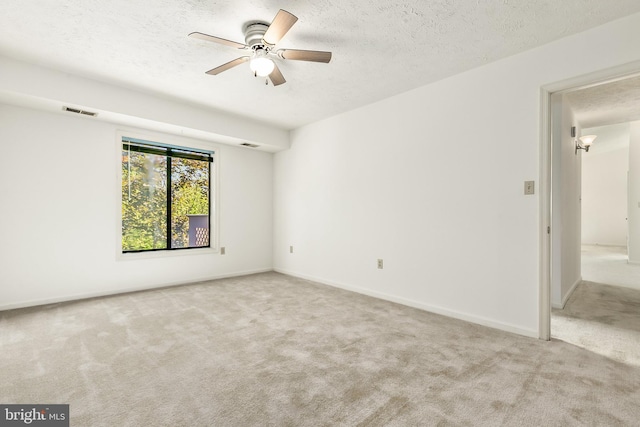 spare room with carpet floors, a textured ceiling, ceiling fan, and baseboards