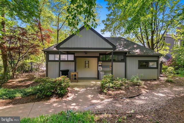 view of front of home with concrete driveway, roof with shingles, and a carport