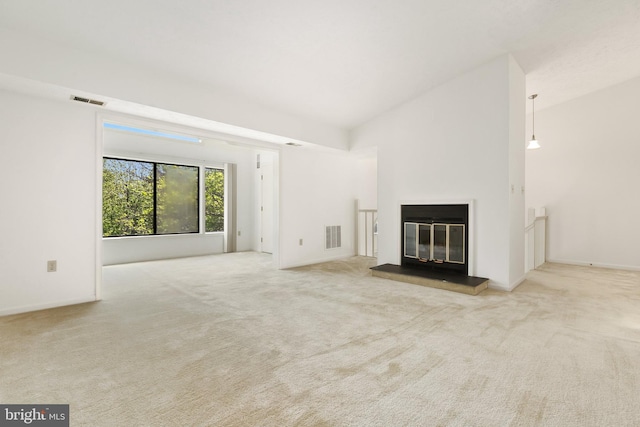 unfurnished living room with carpet flooring and a glass covered fireplace