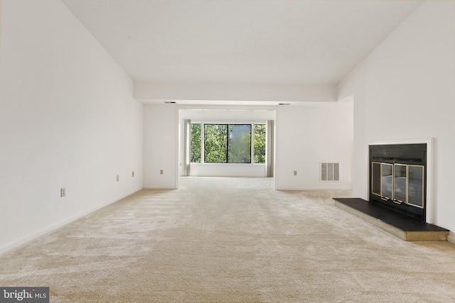 unfurnished living room featuring a glass covered fireplace and carpet floors