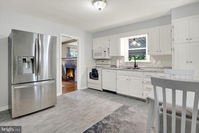 5021 Utah Ave, Harrisburg, PA 17109 - kitchen featuring white appliances, a sink, light wood finished floors, and backsplash