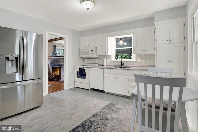 5021 Utah Ave, Harrisburg, PA 17109 - kitchen featuring white appliances, a sink, tasteful backsplash, and white cabinets