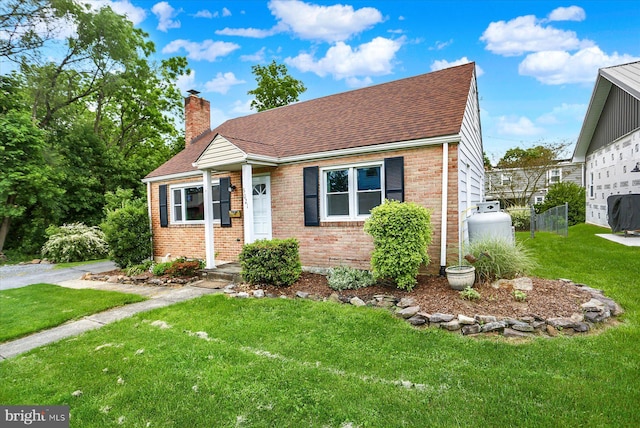 5021 Utah Ave, Harrisburg, PA 17109 - view of front of house featuring brick siding, a chimney, a front yard, and a shingled roof
