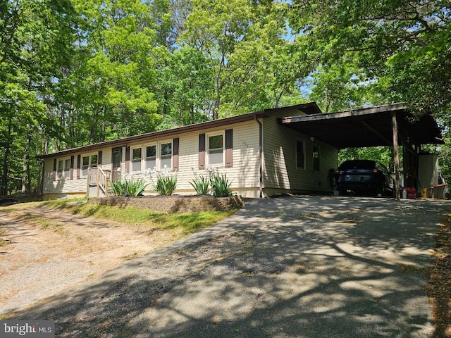 ranch-style home with aphalt driveway and a carport