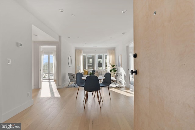 dining room with a wealth of natural light, french doors, baseboards, and light wood-type flooring