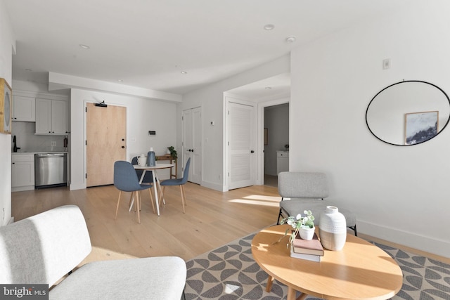 living area featuring light wood-style flooring and baseboards