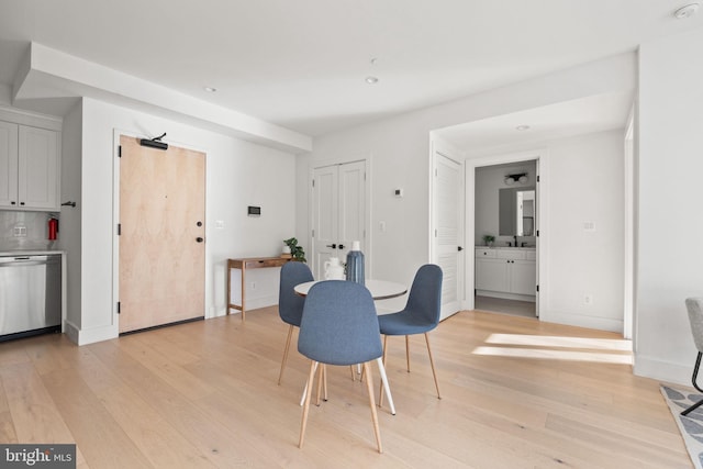 dining area featuring light wood-style flooring and baseboards