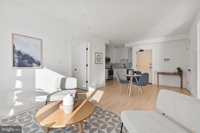 living area featuring light wood-type flooring and recessed lighting