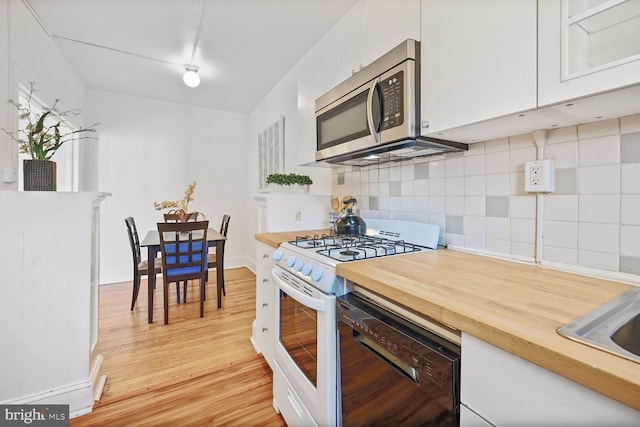 1954 Columbia Rd NW Unit 504, Washington, DC 20009 - kitchen featuring stainless steel microwave, white range with gas stovetop, black dishwasher, and white cabinetry