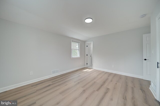 6802 Elbrook Rd, Lanham, MD 20706 - spare room featuring light wood-type flooring, baseboards, visible vents, and vaulted ceiling