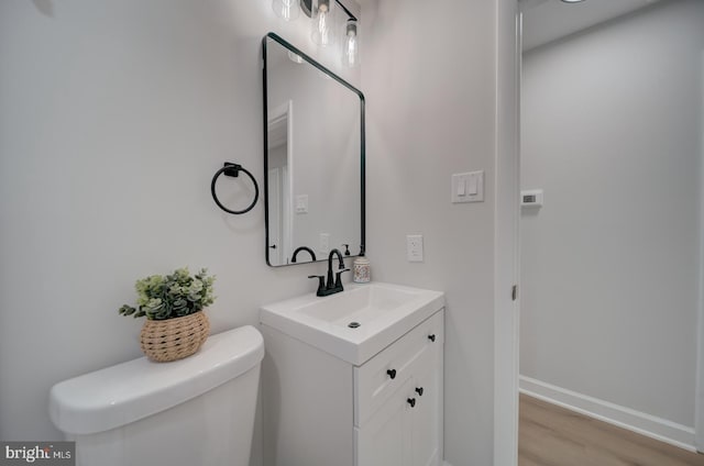 6802 Elbrook Rd, Lanham, MD 20706 - bathroom with toilet, baseboards, vanity, and wood finished floors