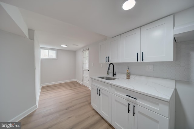 6802 Elbrook Rd, Lanham, MD 20706 - kitchen with white cabinetry, light wood-style floors, light stone countertops, and a sink
