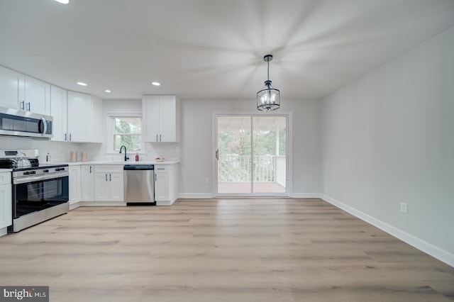 6802 Elbrook Rd, Lanham, MD 20706 - kitchen with white cabinets, appliances with stainless steel finishes, light wood-style flooring, and baseboards