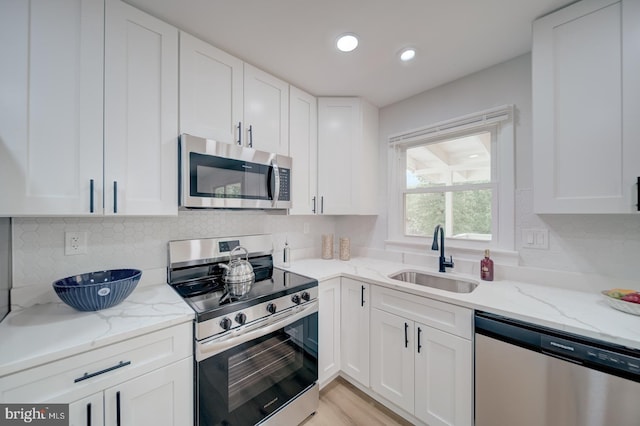 6802 Elbrook Rd, Lanham, MD 20706 - kitchen featuring stainless steel appliances, white cabinets, a sink, and tasteful backsplash