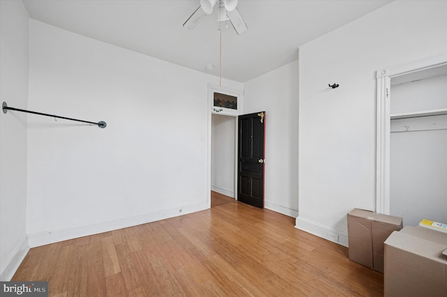 unfurnished bedroom featuring ceiling fan, baseboards, light wood-type flooring, and a closet