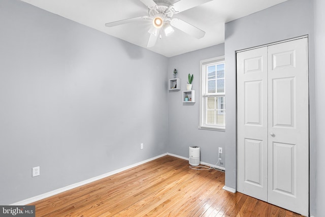 unfurnished bedroom featuring light wood-type flooring, baseboards, a closet, and a ceiling fan