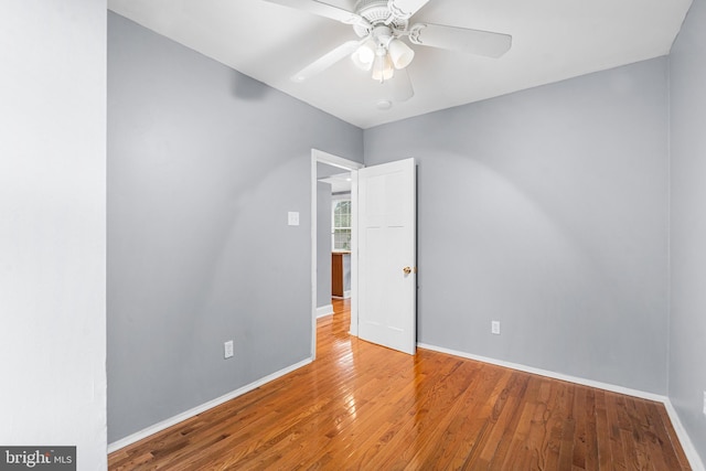 empty room featuring baseboards, ceiling fan, and wood finished floors