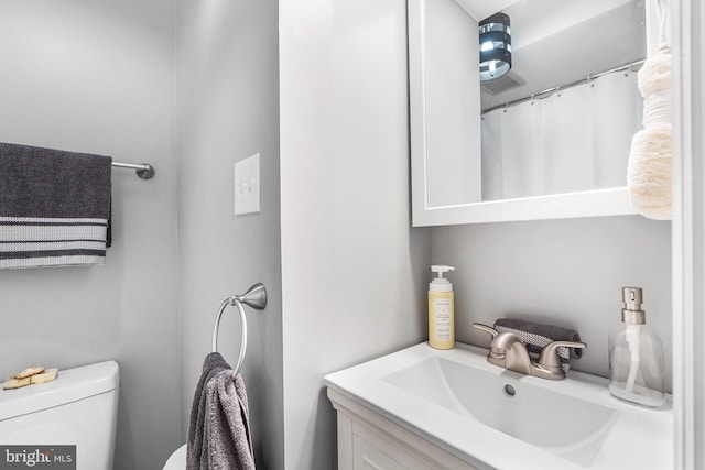 full bathroom with toilet and vanity