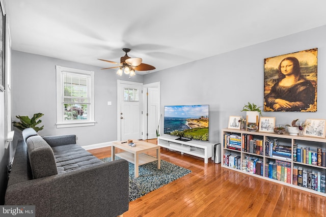 living area featuring ceiling fan, wood finished floors, and baseboards