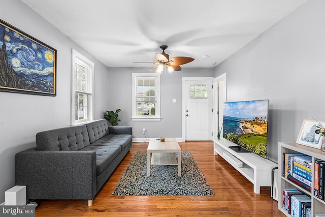 living area with wood finished floors and a ceiling fan