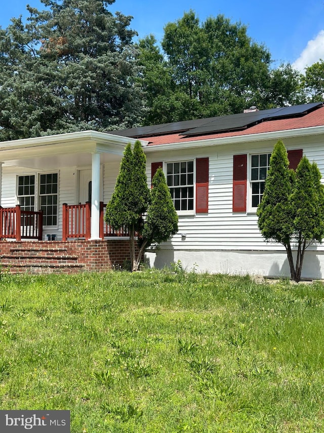15213 Michigan Rd, Woodbridge, VA 22191 - view of front of house with covered porch, roof mounted solar panels, and a front yard