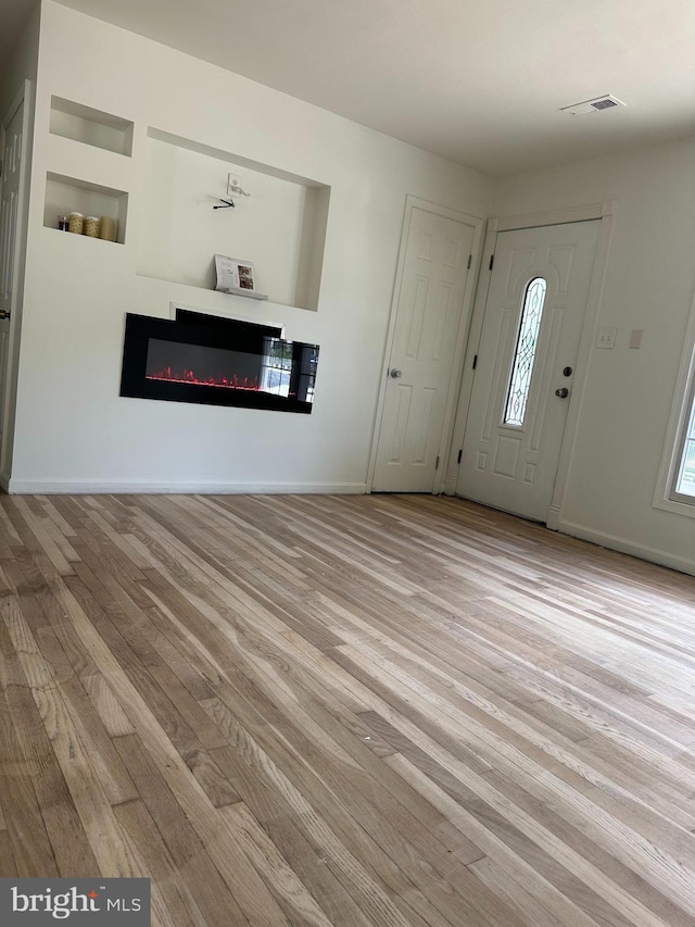 15213 Michigan Rd, Woodbridge, VA 22191 - foyer entrance with wood finished floors, a glass covered fireplace, and baseboards