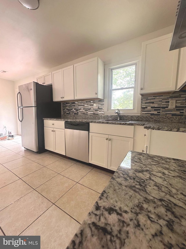 15213 Michigan Rd, Woodbridge, VA 22191 - kitchen featuring appliances with stainless steel finishes, backsplash, light tile patterned flooring, and white cabinets